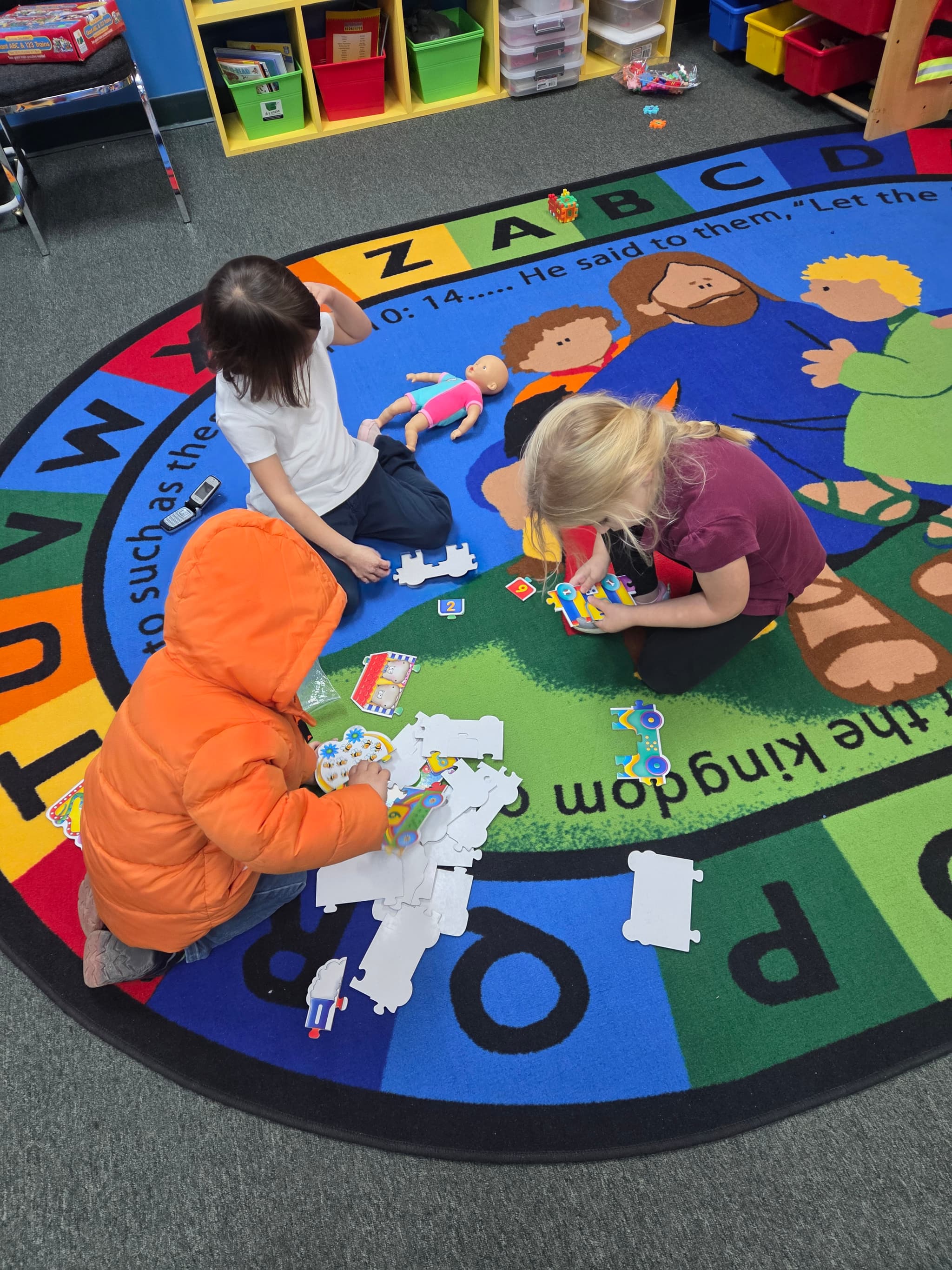 Children playing with puzzles on the classroom rug